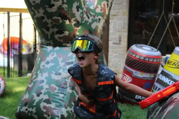 Nerf player taking cover behind an inflatable camo bunker