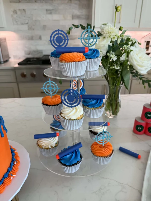 Blue, orange and white Nerf-themed cupcakes with dart and target toppers